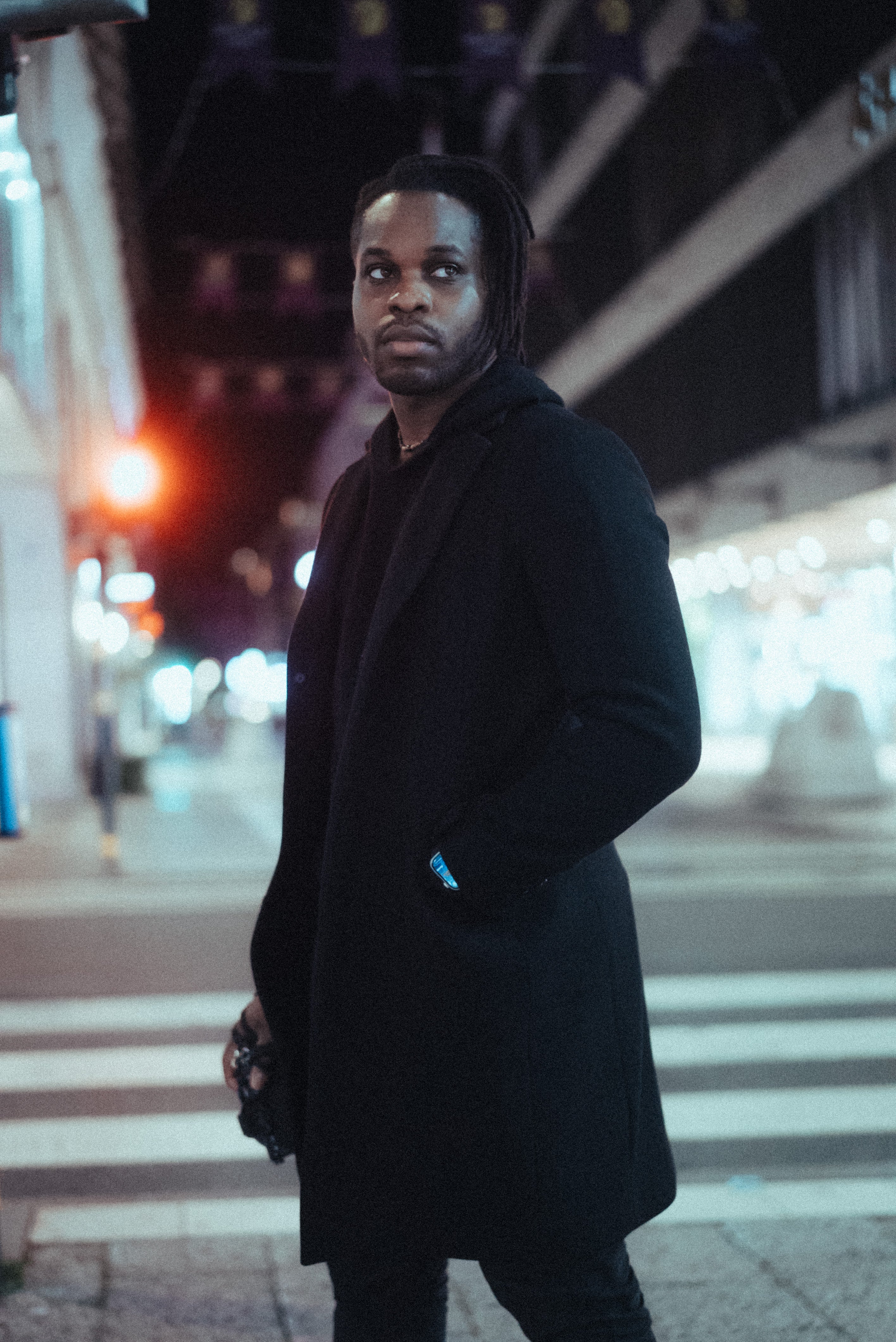 Nattlig bild av Victor Ajayi som går längs en mörk gata, med reflekterande gatlyktor