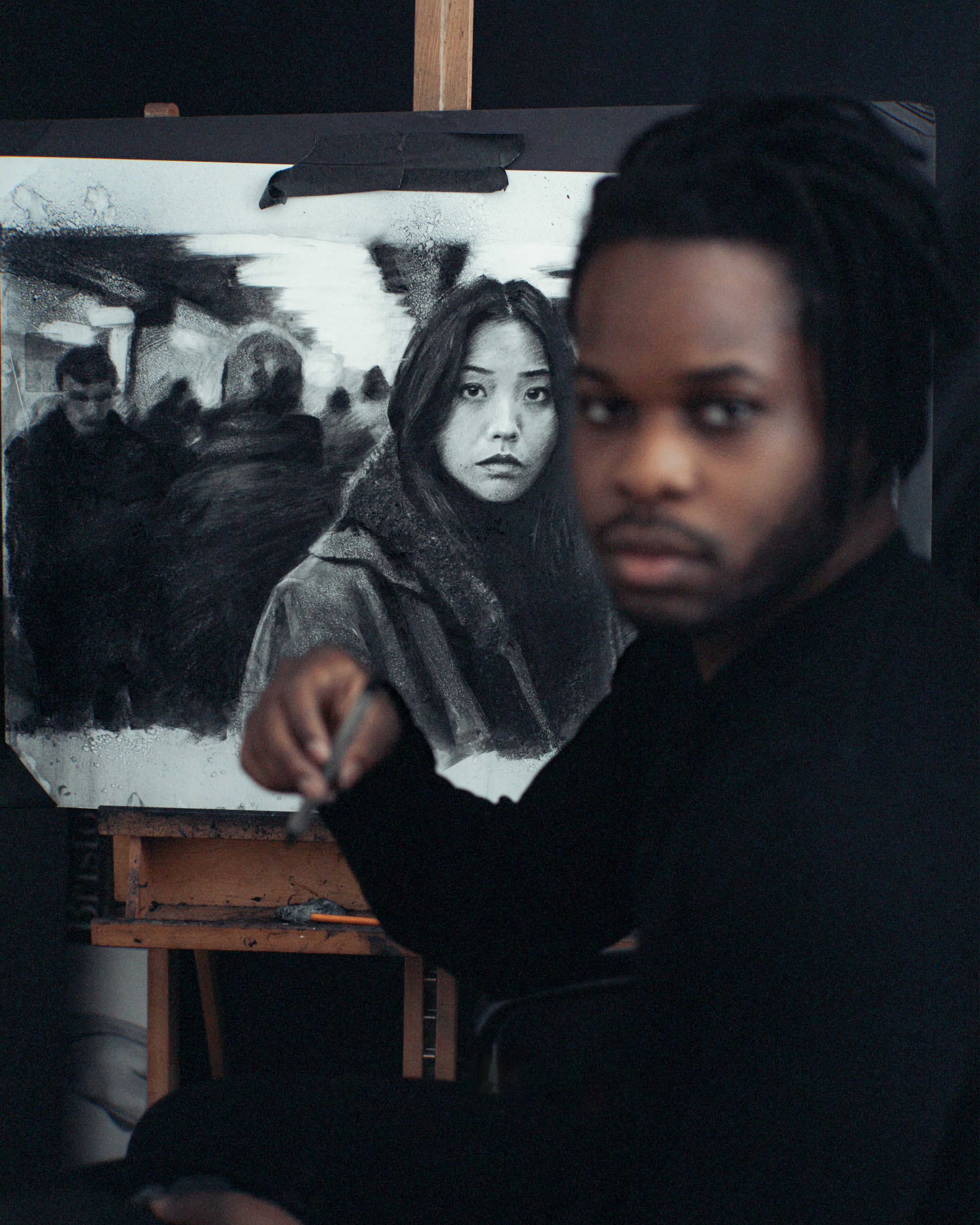 Närbild av Victor Ajayi som målar detaljer på en duk, med intensiv koncentration