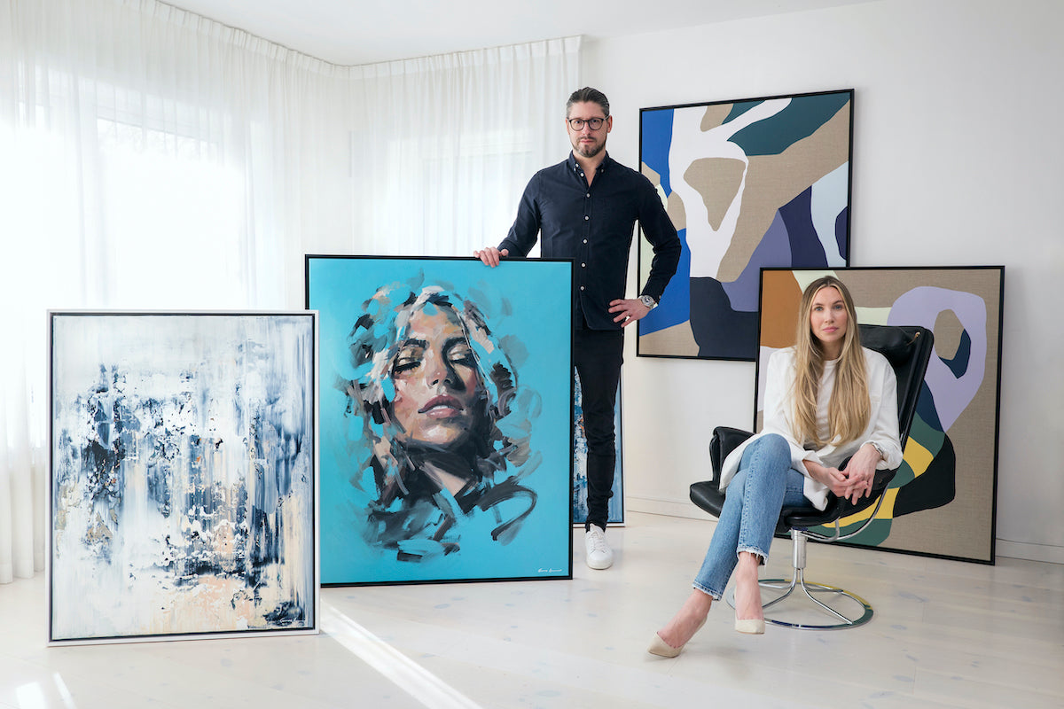 This is a picture showing gallery owners Mimmi Hammar and Tomas Hammar posing together with a few of their artworks